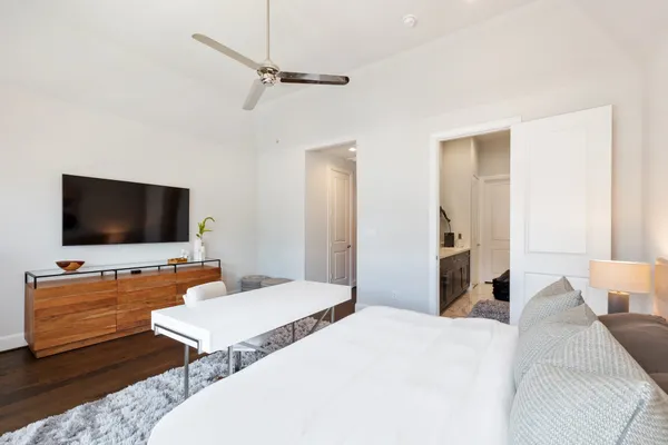 a spacious bedroom with a bed and a flat screen tv