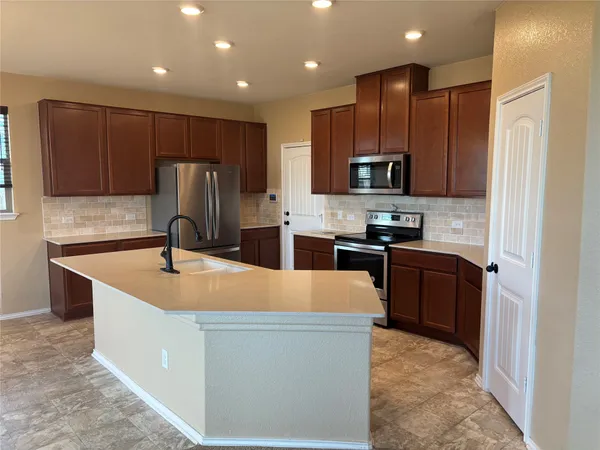 a kitchen with granite countertop a refrigerator and a sink