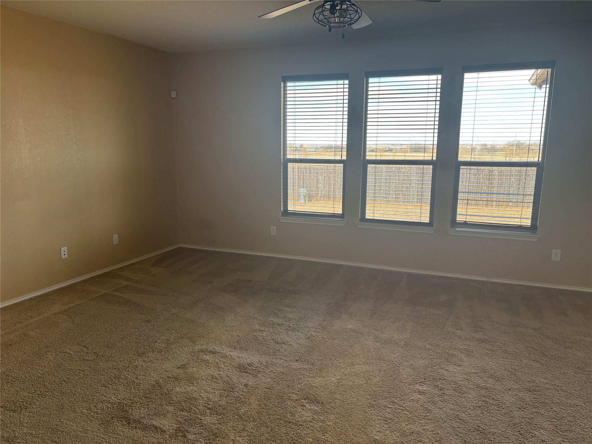 120 Schuylerville Drive Elgin, TX 78621 - Photo 9 of 29 Unfurnished room with dark carpet and ceiling fan