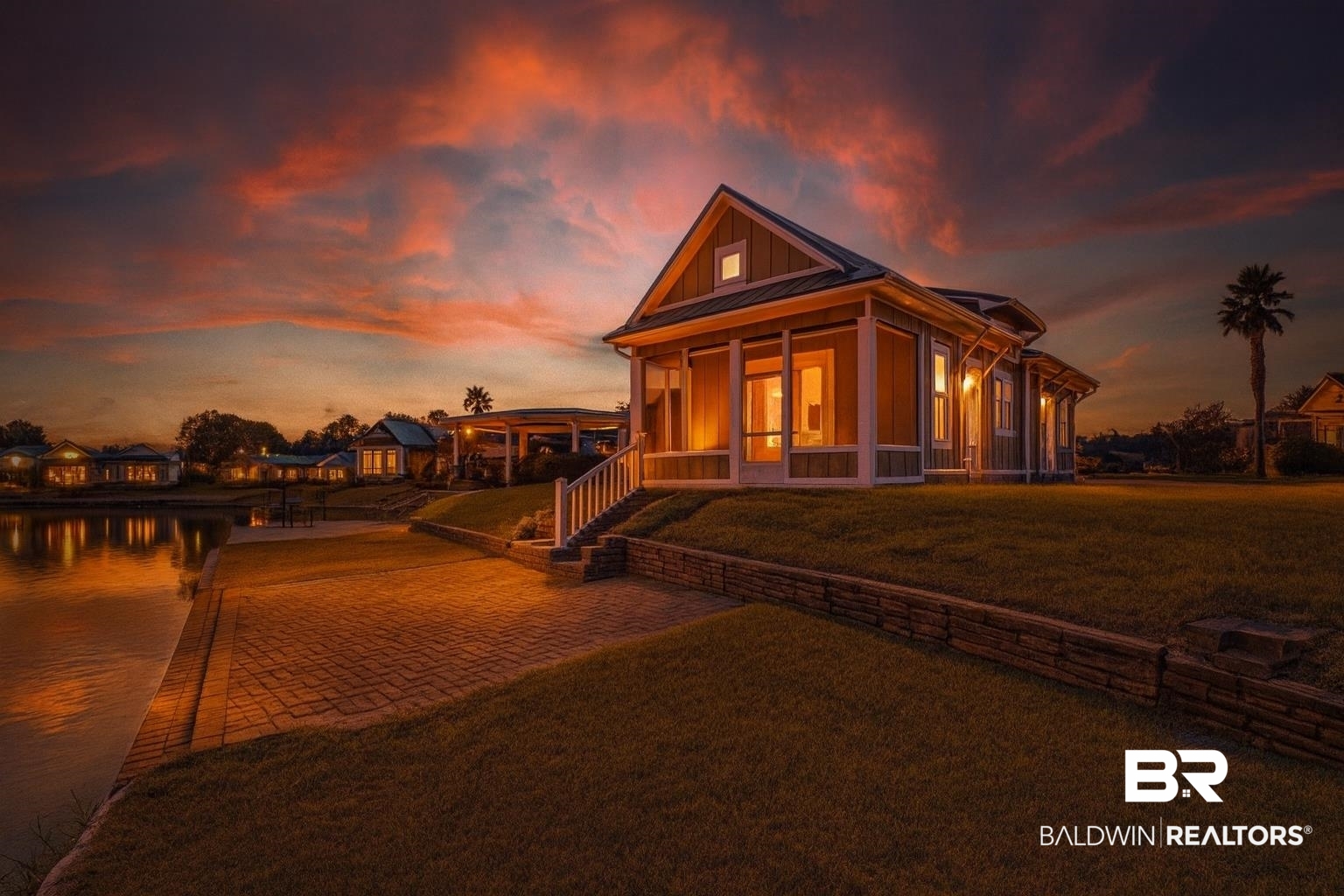 12004 Raptor Court Elberta, AL 36530 - Photo 57 of 57 Back of house at dusk featuring board and batten siding, a lawn, decorative driveway, a sunroom, and covered porch