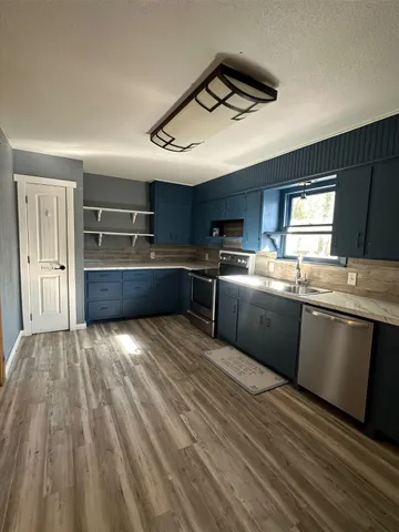 a kitchen with stainless steel appliances granite countertop a sink counter space cabinets and a stove