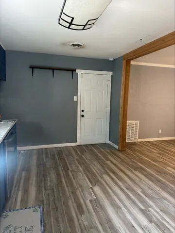 a view of an empty room with wooden floor