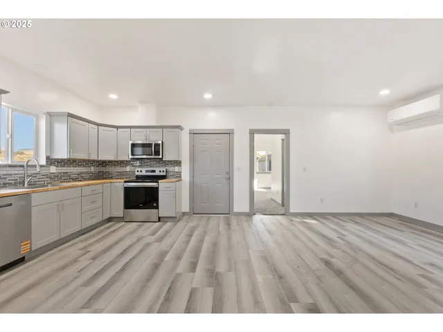 a view of kitchen with granite countertop cabinets and refrigerator