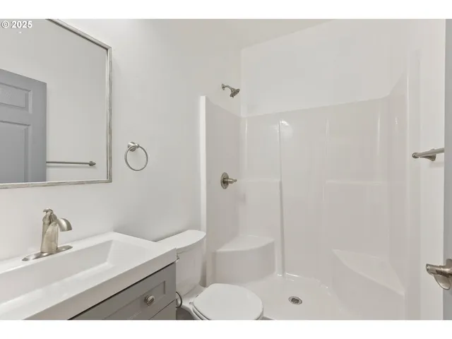 a bathroom with a sink mirror and shower