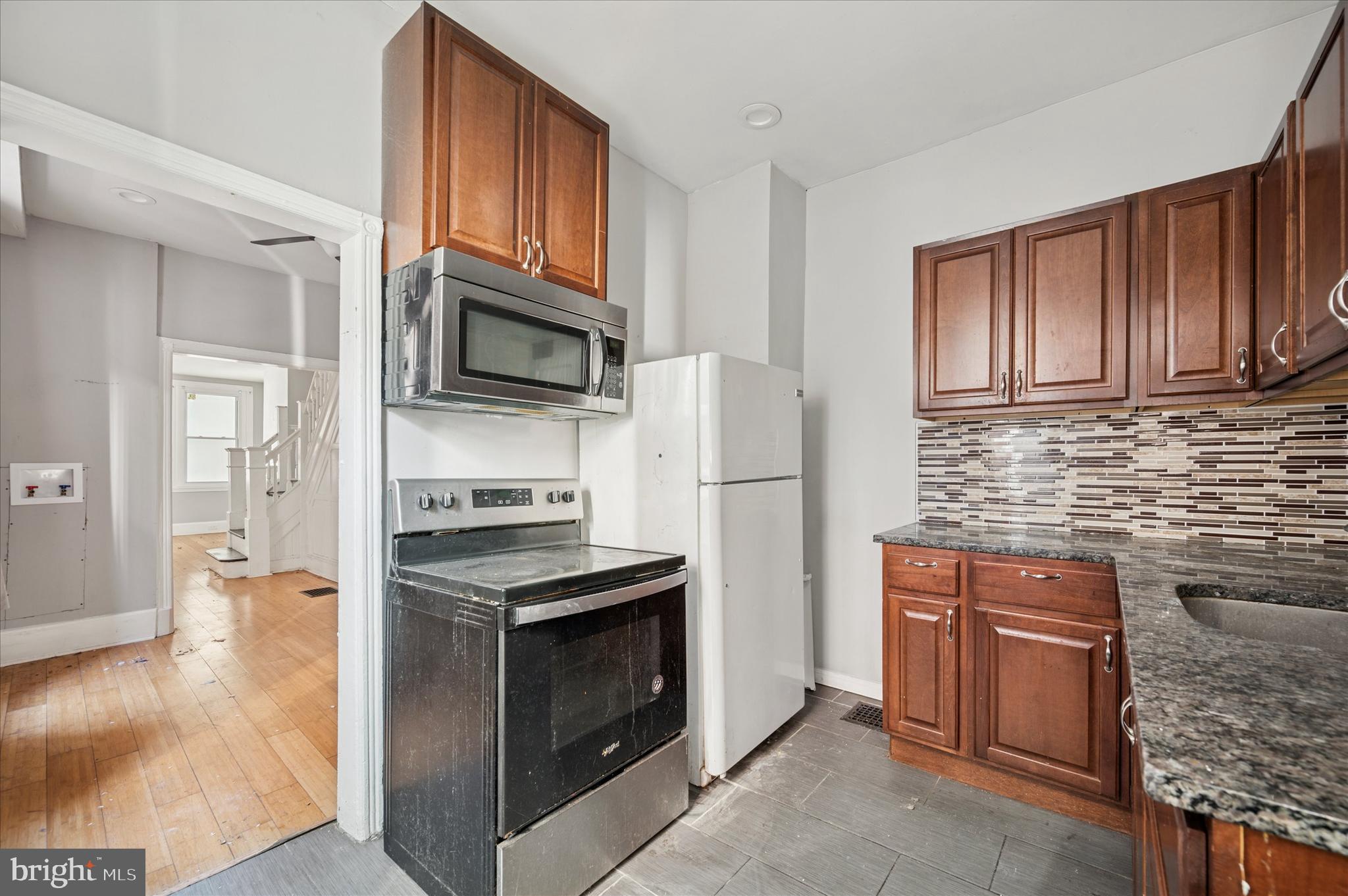 809 East Locust Avenue Philadelphia, PA 19138 - Photo 17 of 23 a kitchen with granite countertop wooden cabinets stainless steel appliances and a counter space