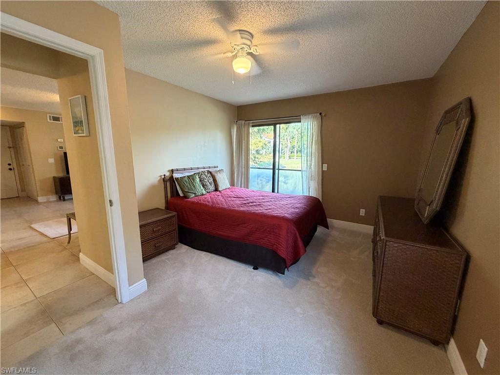 2070 Arbour Walk Circle, Unit 3214 Naples, FL 34109 - Photo 7 of 12 a bedroom with a bed and a chandelier