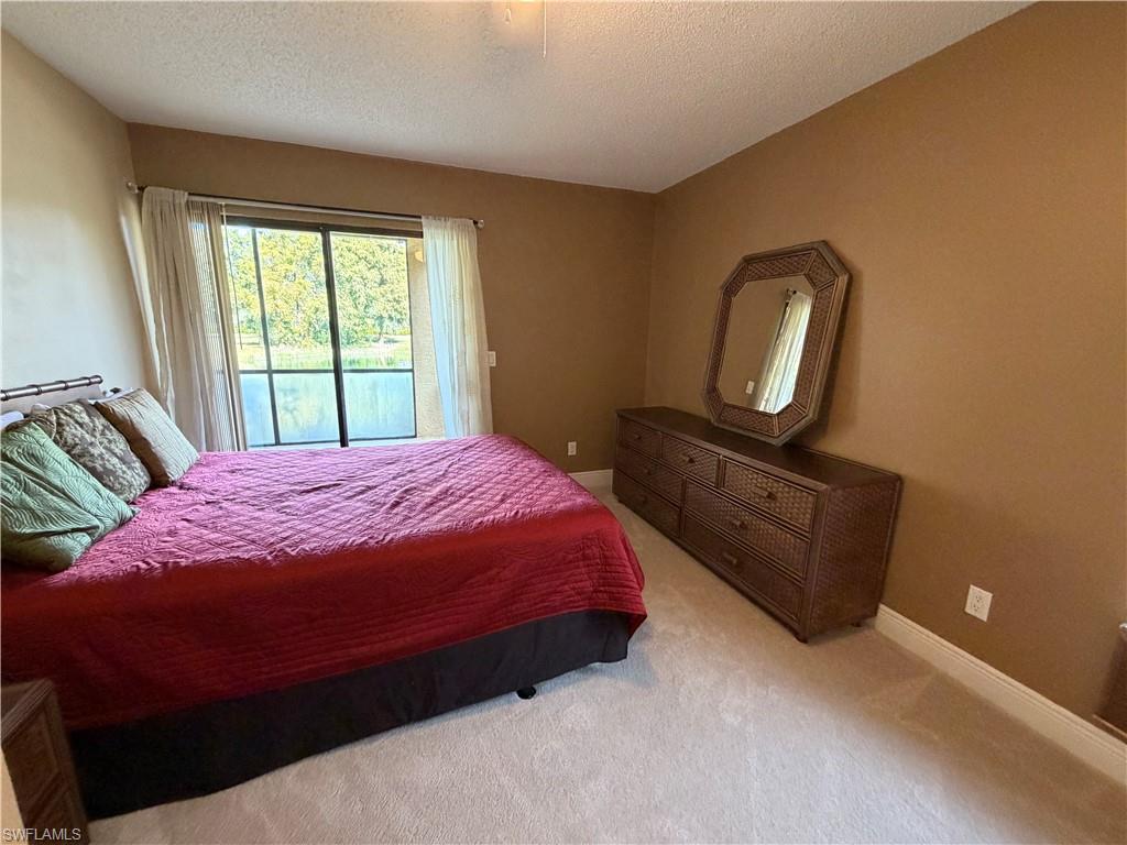 2070 Arbour Walk Circle, Unit 3214 Naples, FL 34109 - Photo 8 of 12 a bedroom with a bed dresser and a window