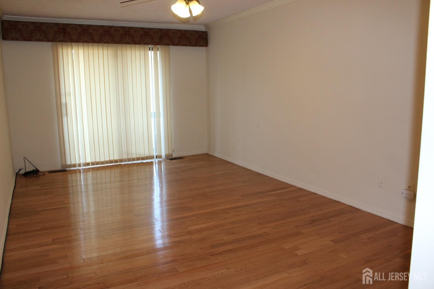 157 Westgate Drive Edison, NJ 08820 - Photo 29 of 40 an empty room with wooden floor and windows