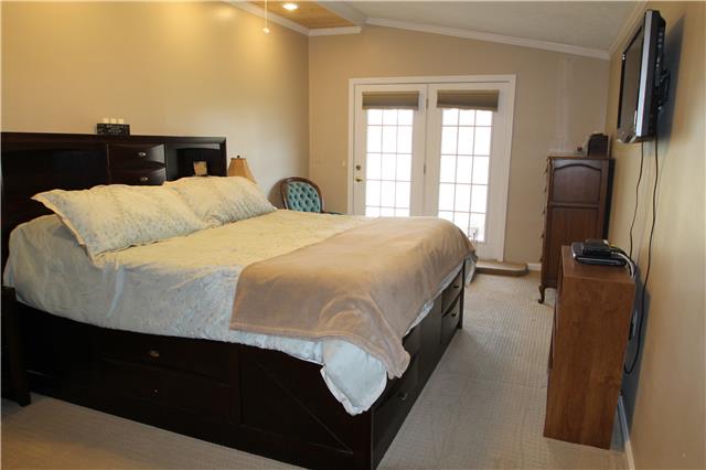 7470 Shoals Branch Road Primm Springs, TN 38476 - Photo 3 of 12 a bedroom with a bed flat screen tv and windows