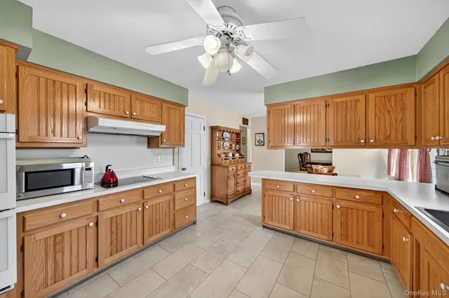 a kitchen with kitchen island granite countertop a sink window and cabinets