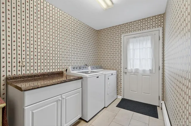 a utility room with a sink a cabinetry and a window
