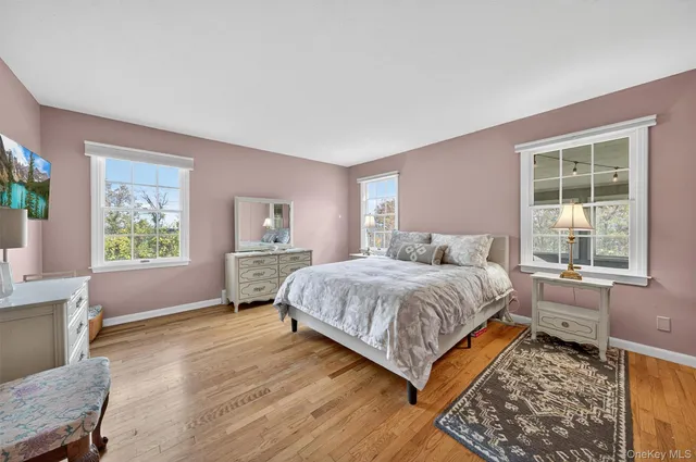 a spacious bedroom with a bed and wooden floor