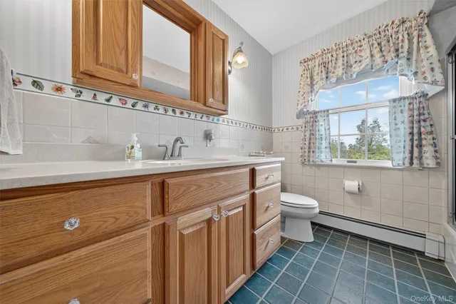 a bathroom with a toilet sink and mirror