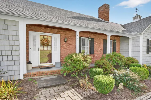 a front view of a house with a lots of potted plants