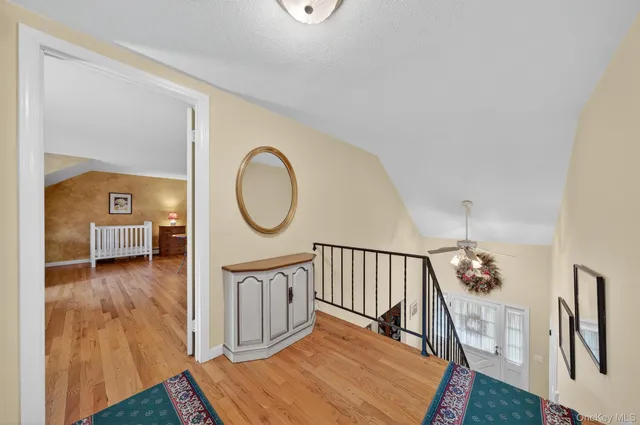 a view of a hallway with wooden floor and front door