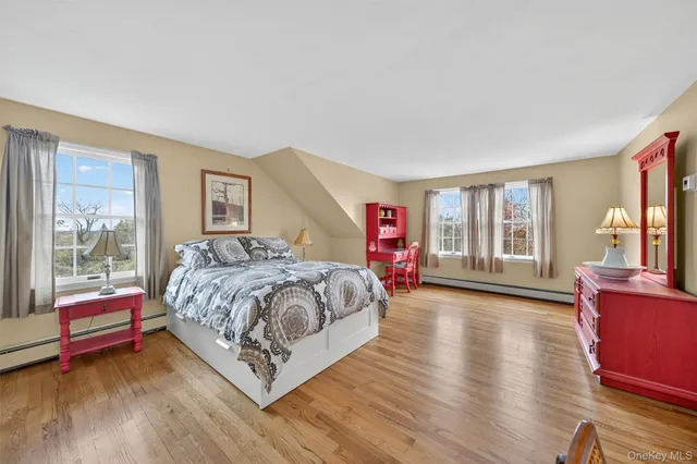 a spacious bedroom with a bed and wooden floor