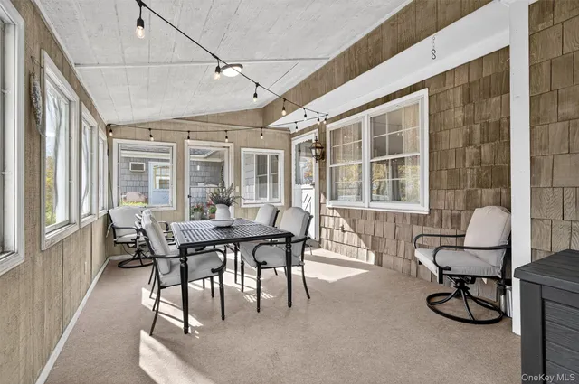 a view of a chairs and table on the wooden roof deck