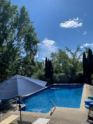 a view of a house with backyard and sitting area
