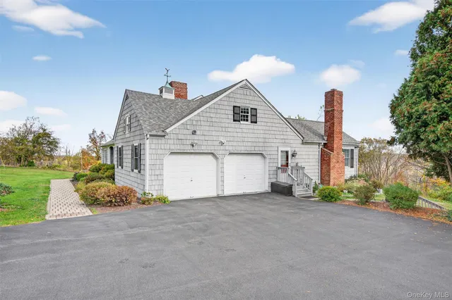 a front view of a house with a garden and trees