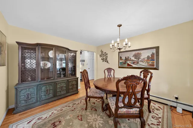 a dining room with furniture a chandelier and wooden floor