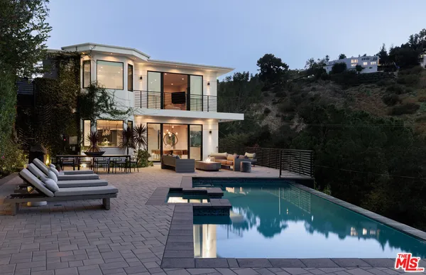 a view of swimming pool with outdoor seating and plants