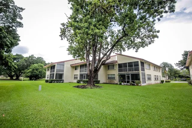 a view of a house with a big yard and large trees
