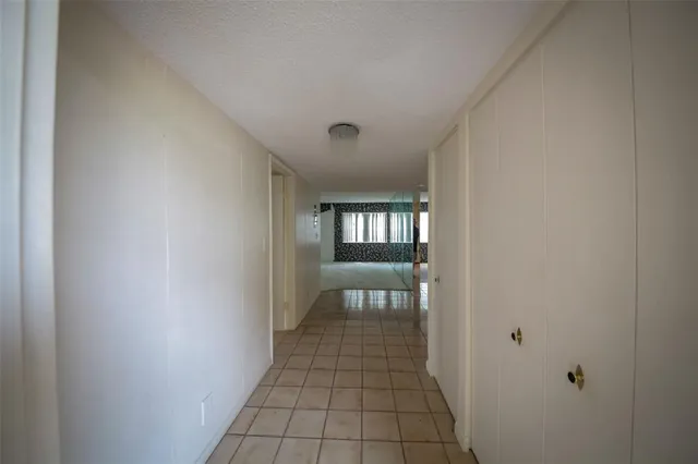 a hallway with wooden floor windows and livingroom