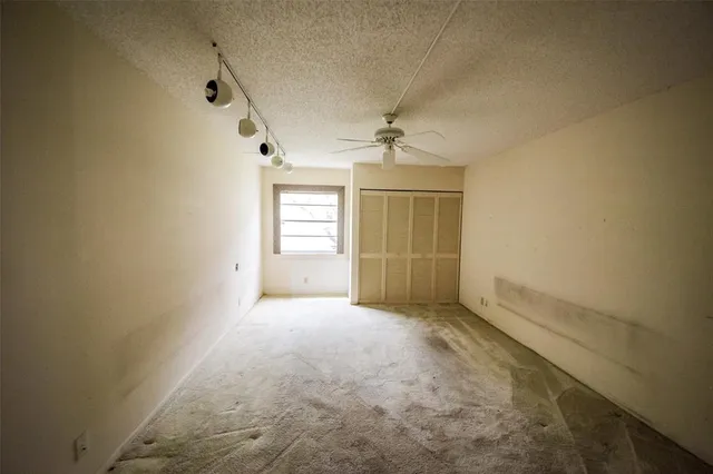 an empty room with windows and chandelier