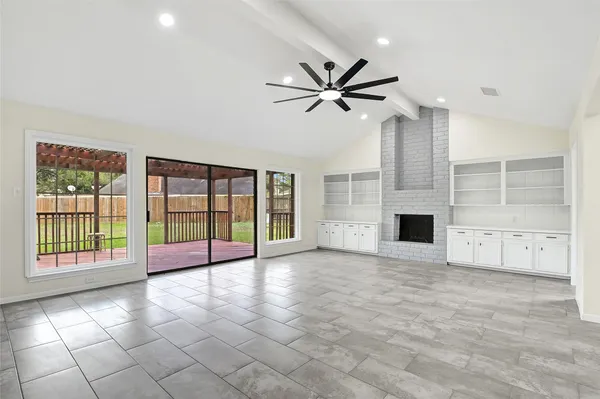 a view of an empty room with a fireplace and a window