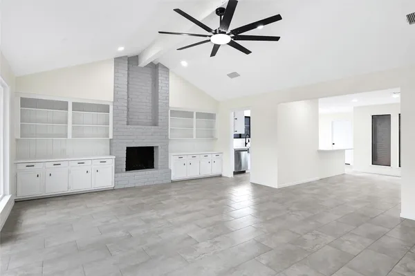 an empty room with windows and fireplace