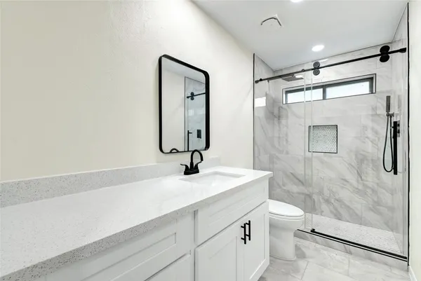 a bathroom with a sink a toilet and shower