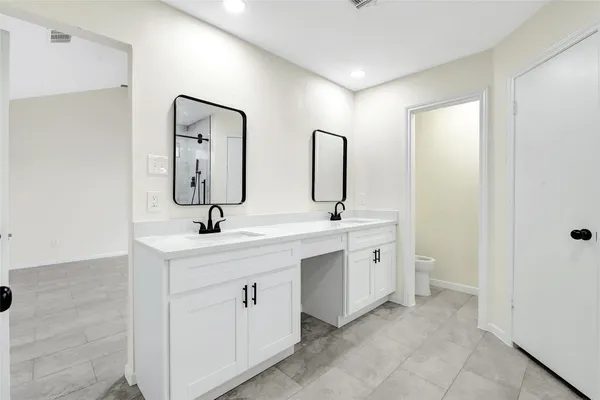 a spacious bathroom with 2 sink and a mirror