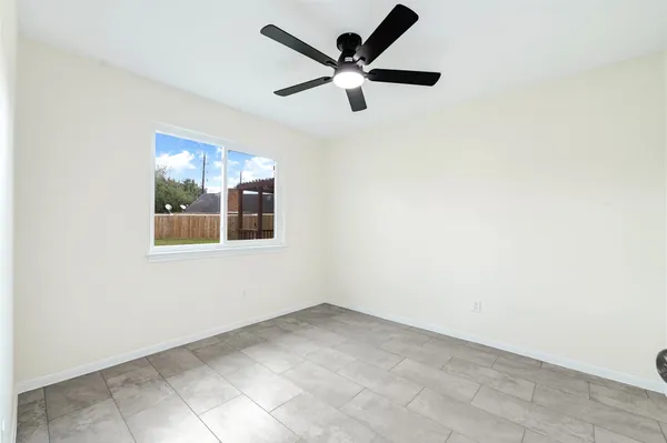 an empty room with a window and a ceiling fan