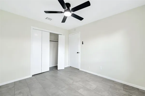 an empty room with a ceiling fan and a ceiling fan