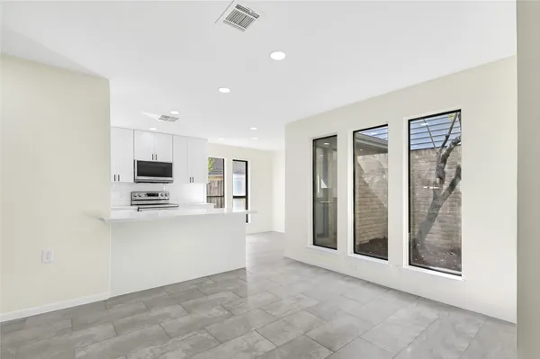 a view of kitchen with stainless steel appliances refrigerator stove microwave and cabinets