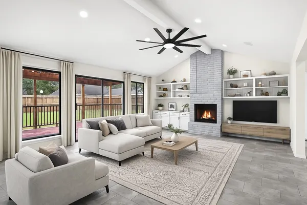 a living room with furniture a fireplace and a large window