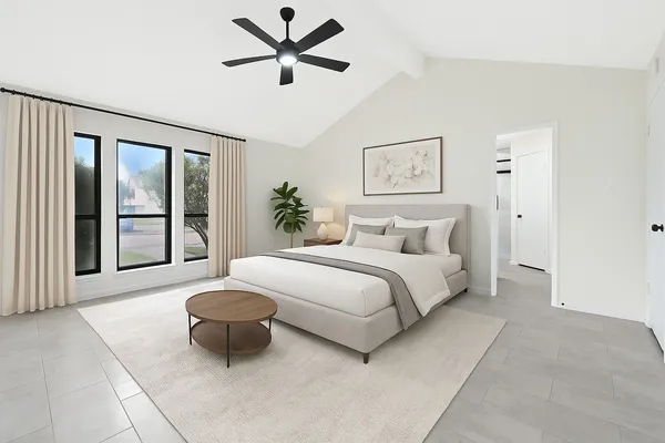 a spacious bedroom with a bed and a large window