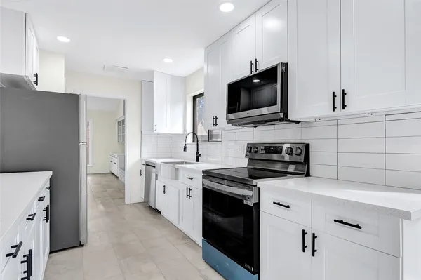 a kitchen with cabinets stainless steel appliances and a sink