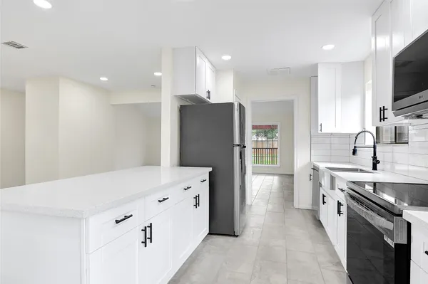 a kitchen with stainless steel appliances a refrigerator sink and microwave