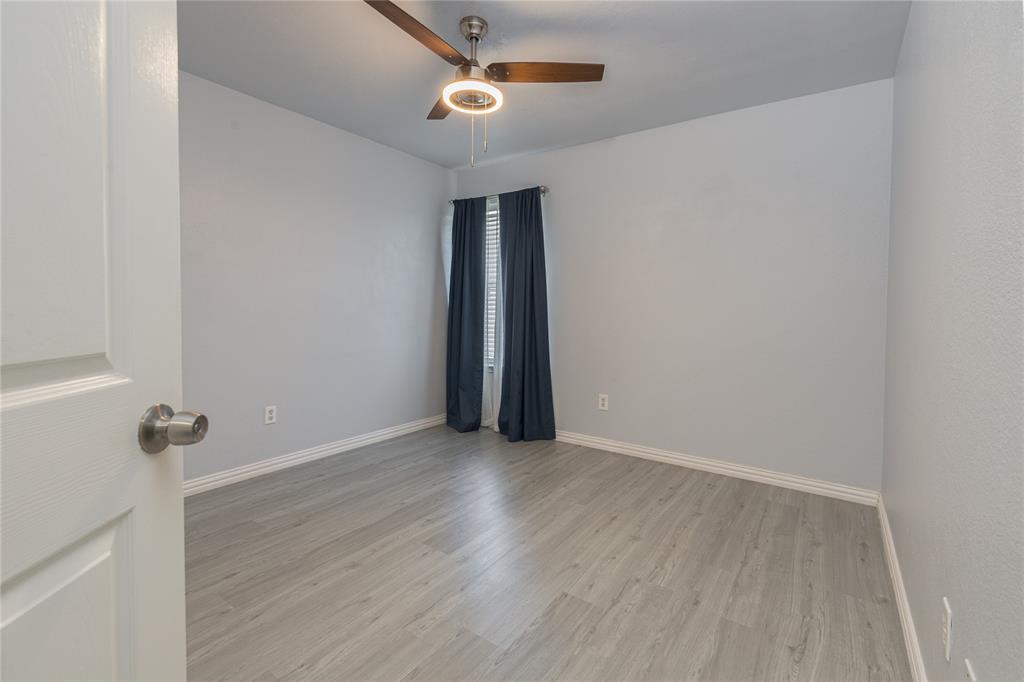 7313 Diamond Springs Trail Fort Worth, TX 76123 - Photo 29 of 40 an empty room with wooden floor fan and windows