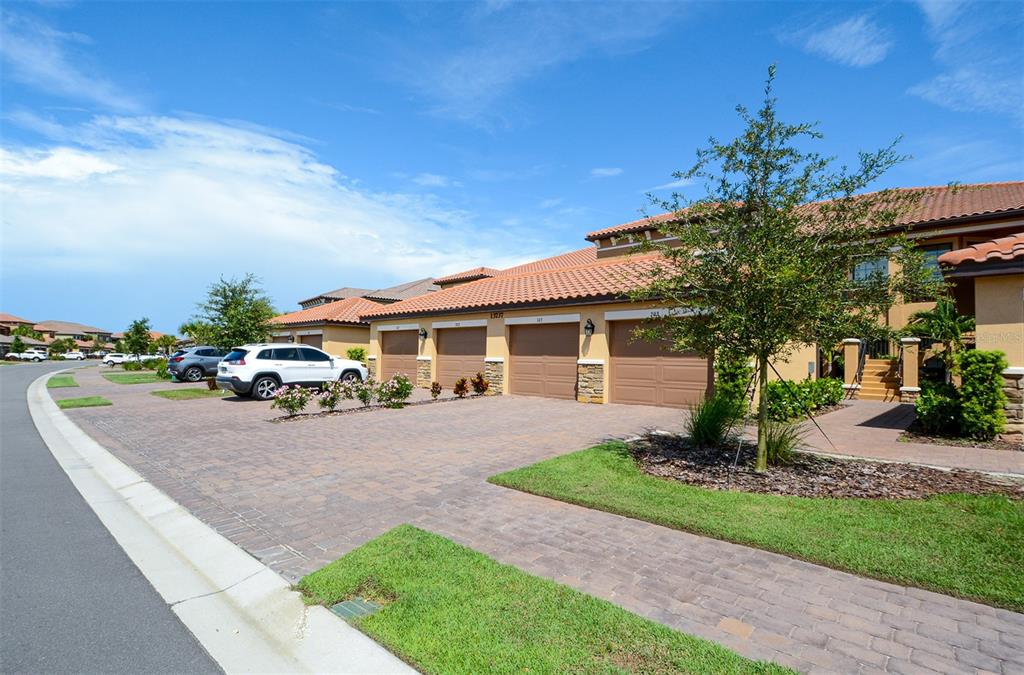 13737 Messina Loop, Unit 202 Lakewood Ranch, FL 34211 - Photo 1 of 49 a front view of a house with garden