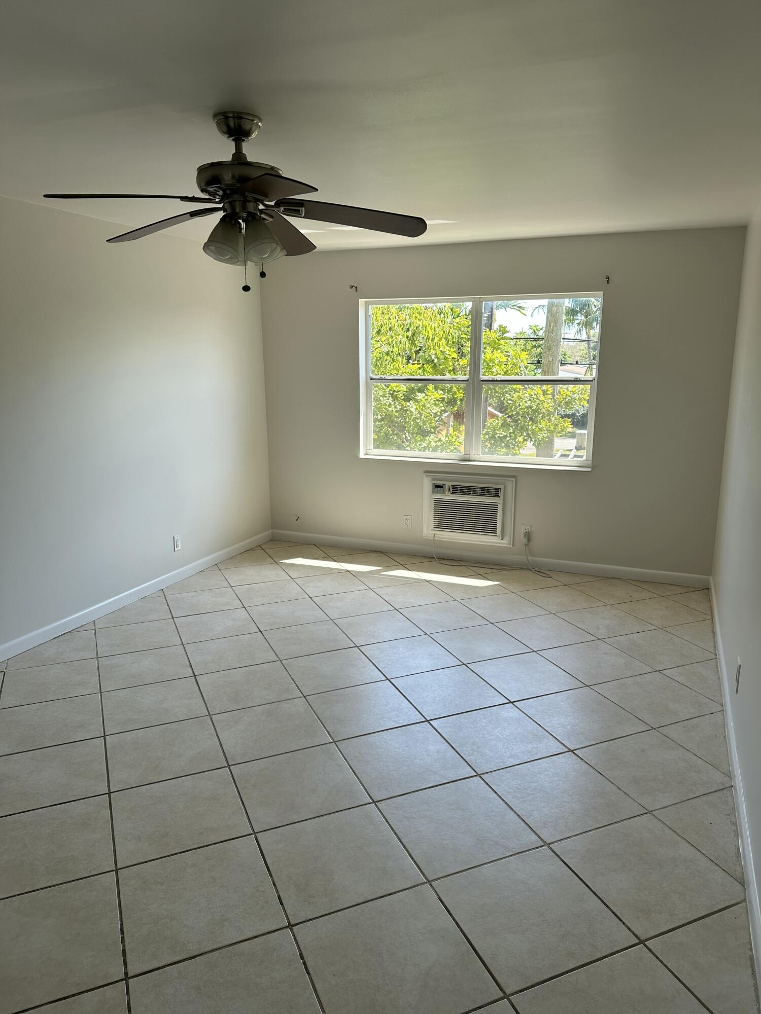 1480 East Sample Road, Unit 207 Pompano Beach, FL 33064 - Photo 4 of 14 a view of an empty room with a window