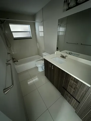 a bathroom with a double vanity sink a toilet and mirror