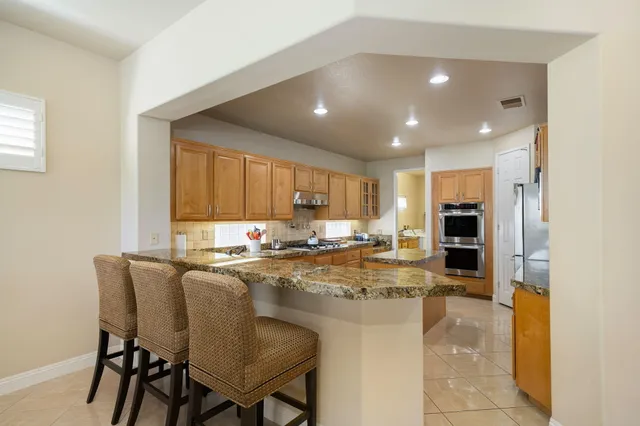 a kitchen with a table chairs refrigerator and cabinets
