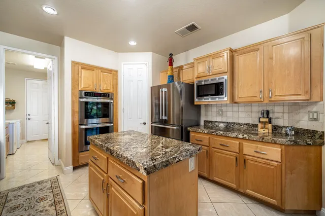 a kitchen with stainless steel appliances granite countertop a stove microwave and refrigerator