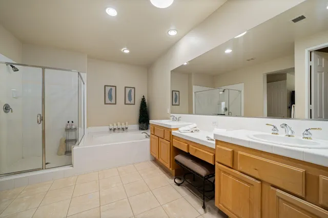 a spacious bathroom with a granite countertop sink a mirror and a bathtub