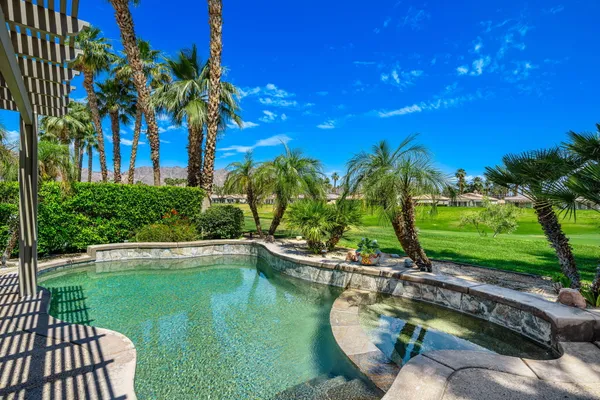 a view of a swimming pool with a patio and a yard