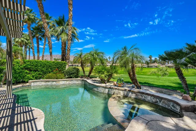a view of a swimming pool with a patio and a yard