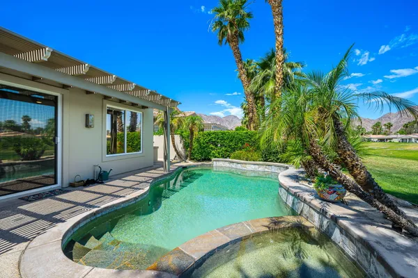 a swimming pool with outdoor seating and yard
