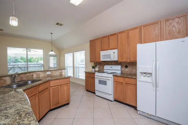 a kitchen with a stove a refrigerator and a sink